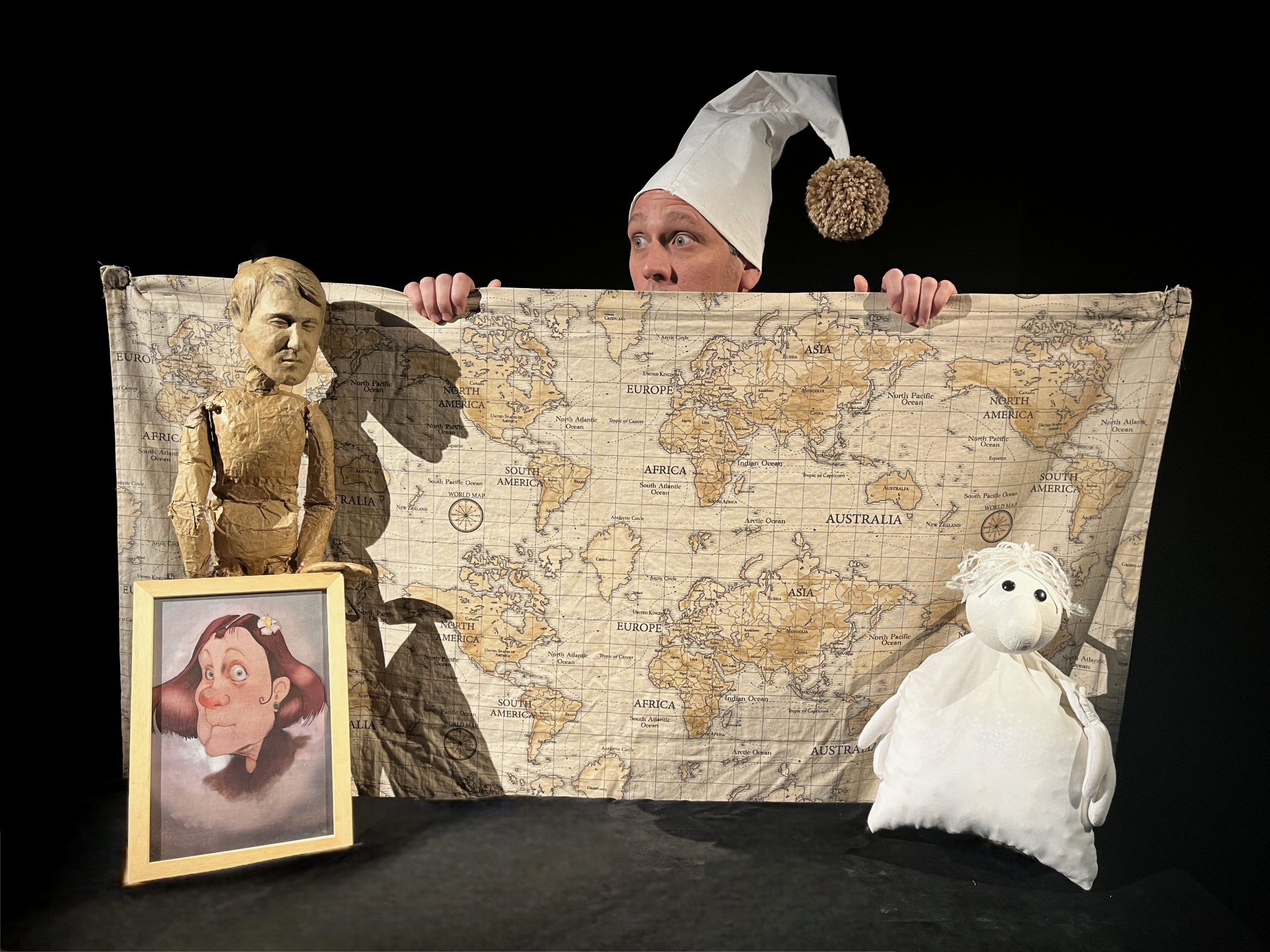 Antoine, son doudou et une photographie de famille devant une grande carte du monde.